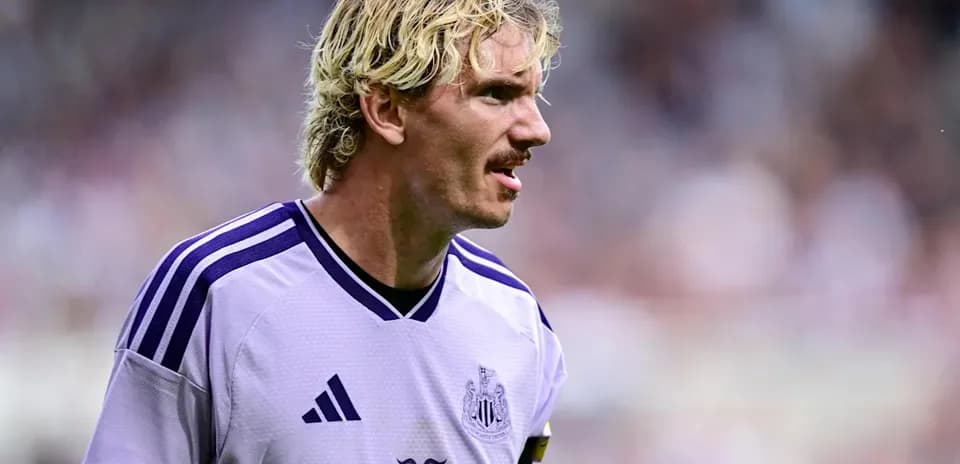 Futbolchi maydonda harakatda, qora kostyumda
