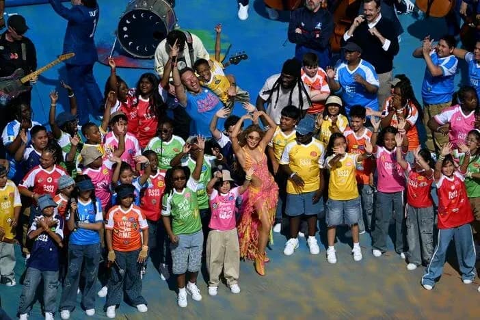 Performers and children celebrating on stage together Performers and children celebrating on stage together