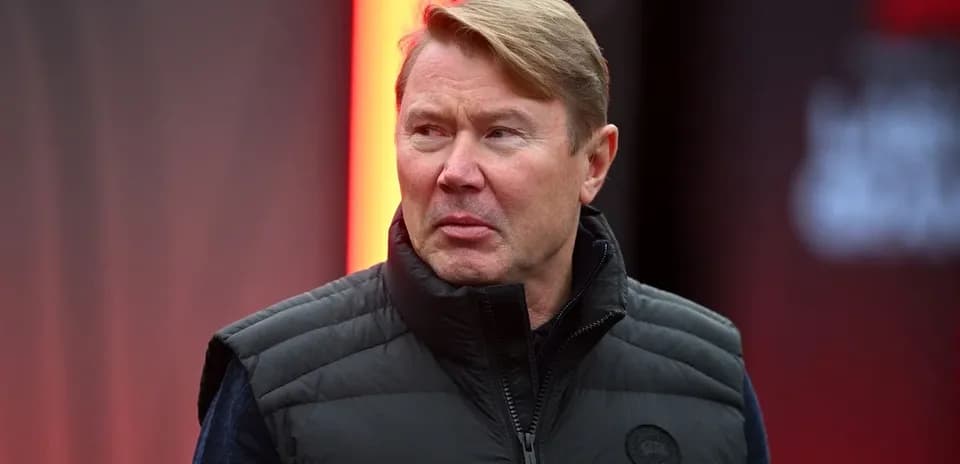 Shaxs qora jiletda sahnaga yaqinlashmoqda