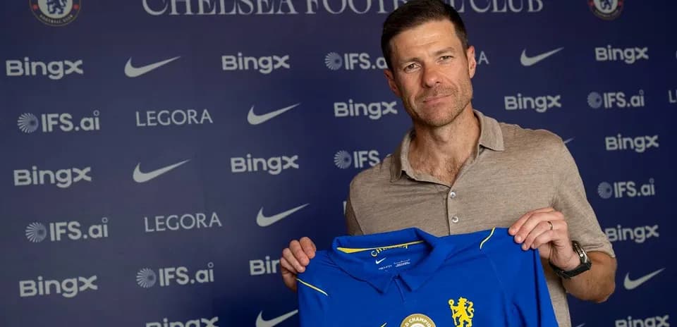 New coach holding Chelsea jersey at press conference