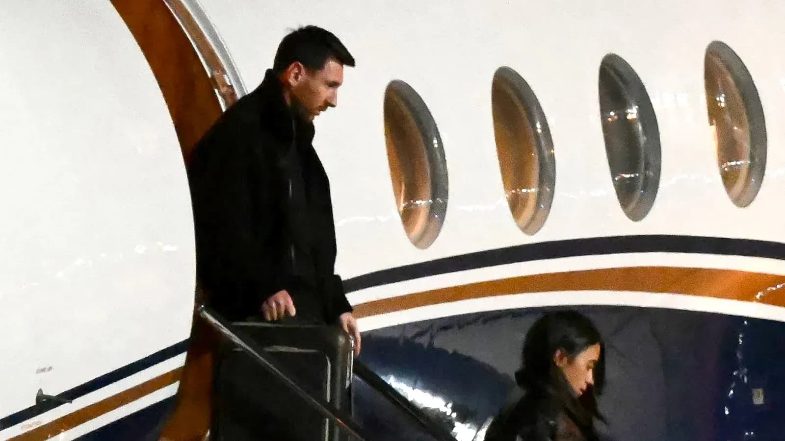 Lionel Messi exiting private jet with companion