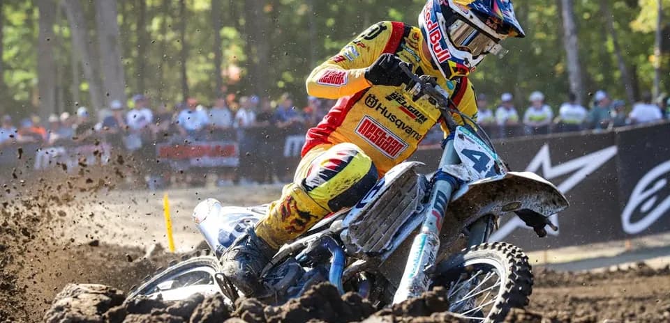 Motocross rider navigating through muddy terrain