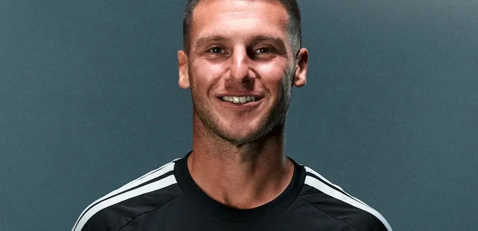Futbolchi qora forma kiygan, kulgan yuz