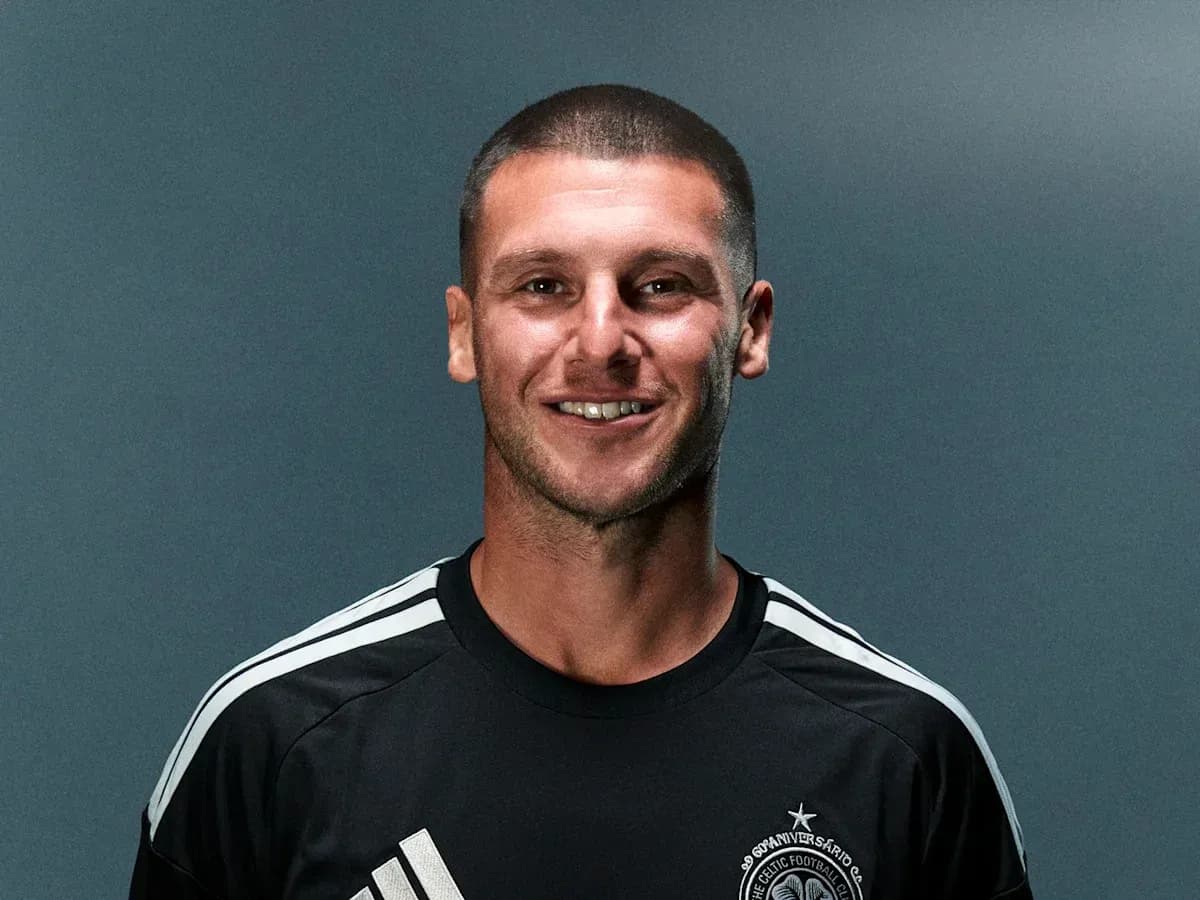 Futbolchi qora forma kiygan, kulgan yuz
