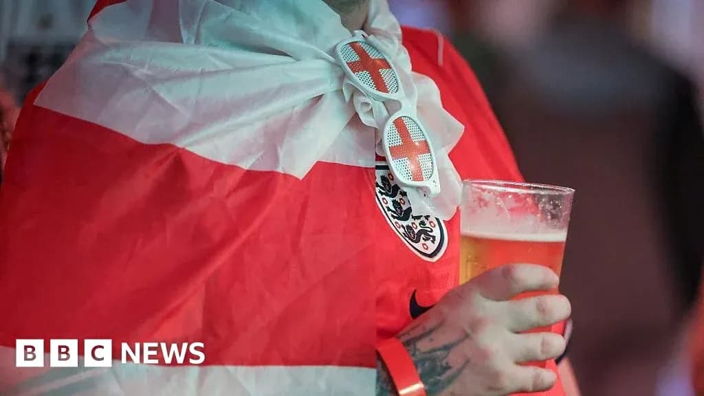 Fan wearing England flag and holding beer Fan wearing England flag and holding beer