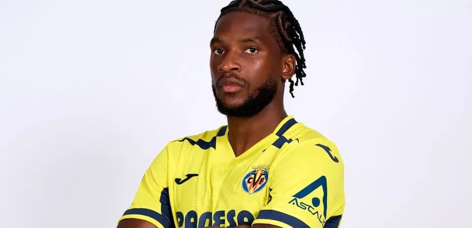 Futbolchi sari formada, qo'lini oldida tutgan