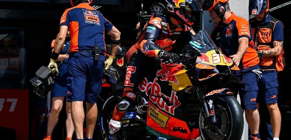 Rider preparing to leave pit with team assistance