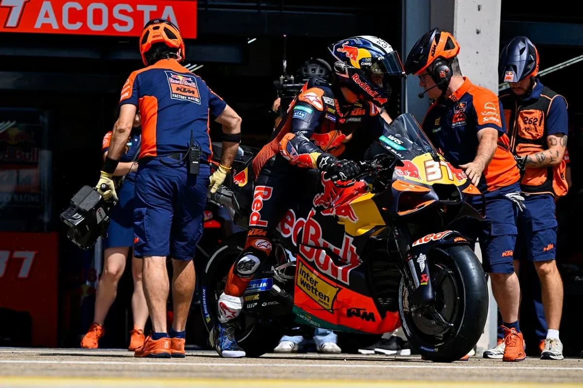 Rider preparing to leave pit with team assistance