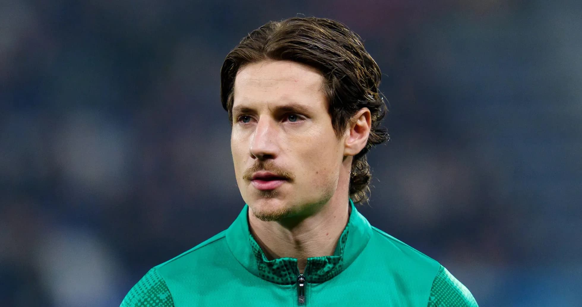 Football player in green training kit on field