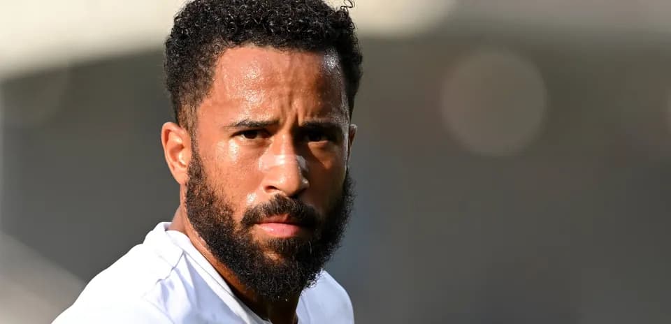 Futbolchi maydonga tayyorlanmoqda, diqqat bilan qaramoqda