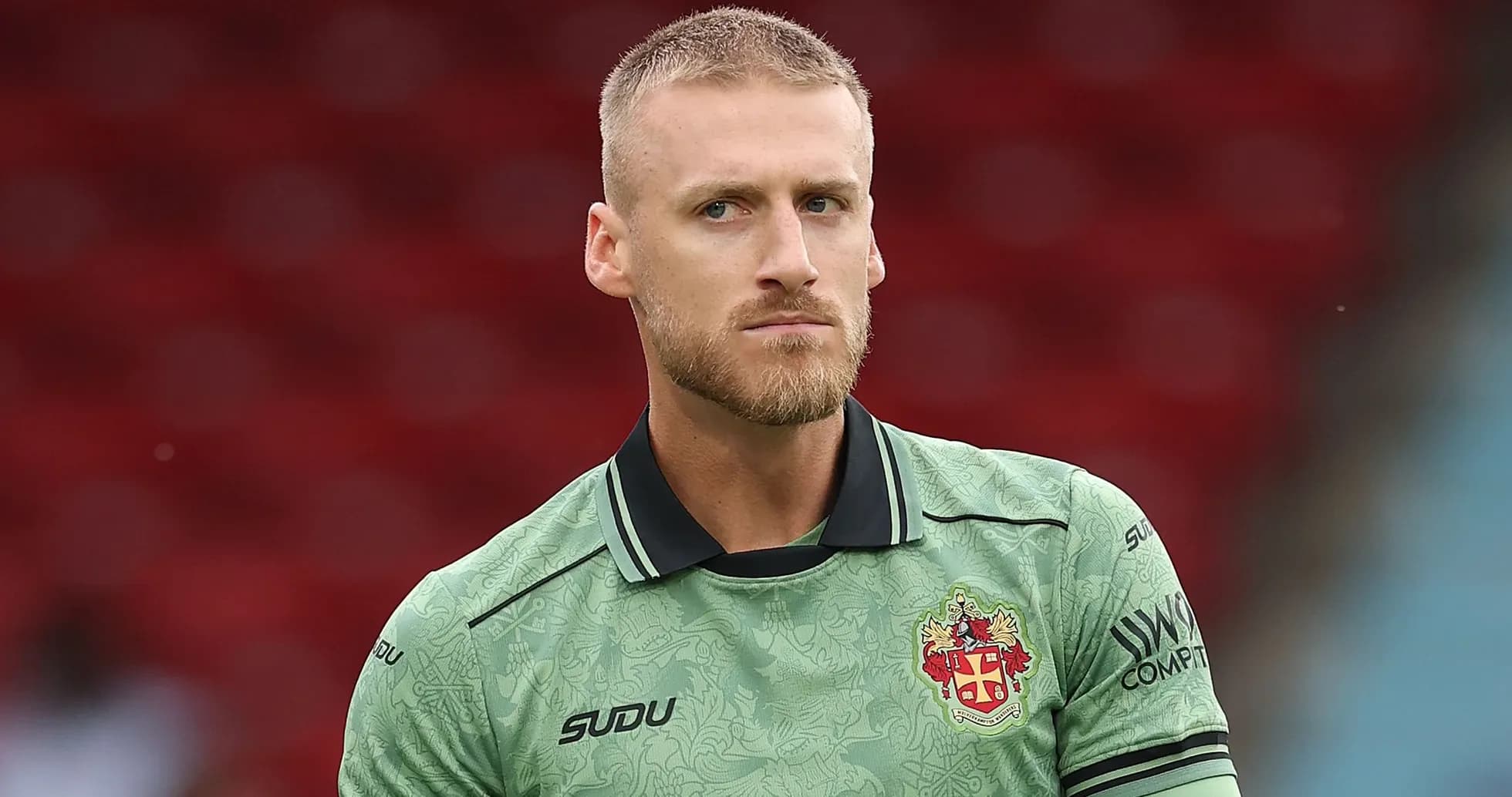 Goalkeeper in green kit during match warm-up