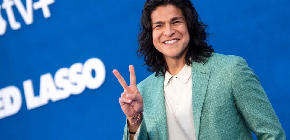 Shirted man giving peace sign at event