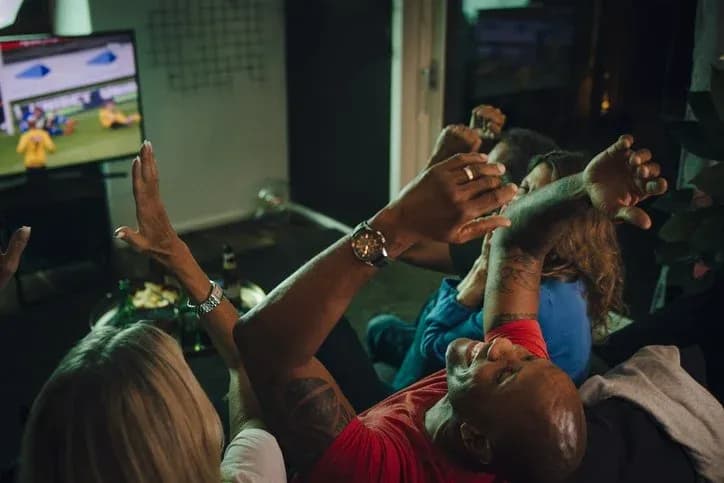People celebrating while watching a football match People celebrating while watching a football match