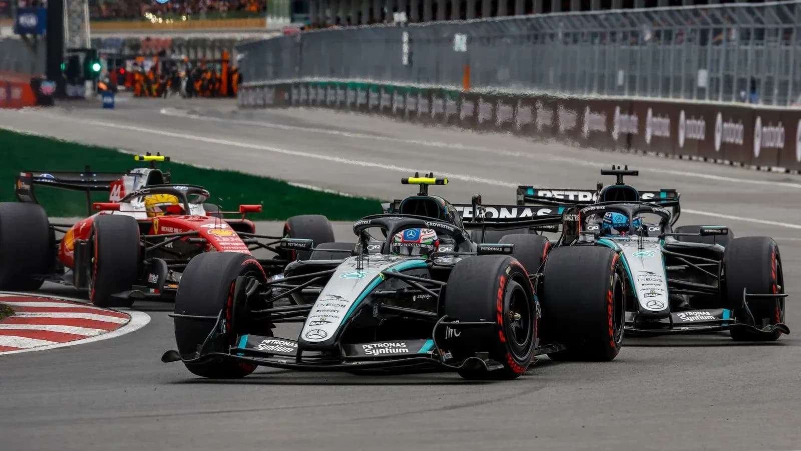 Formula 1 cars racing closely on track Formula 1 cars racing closely on track