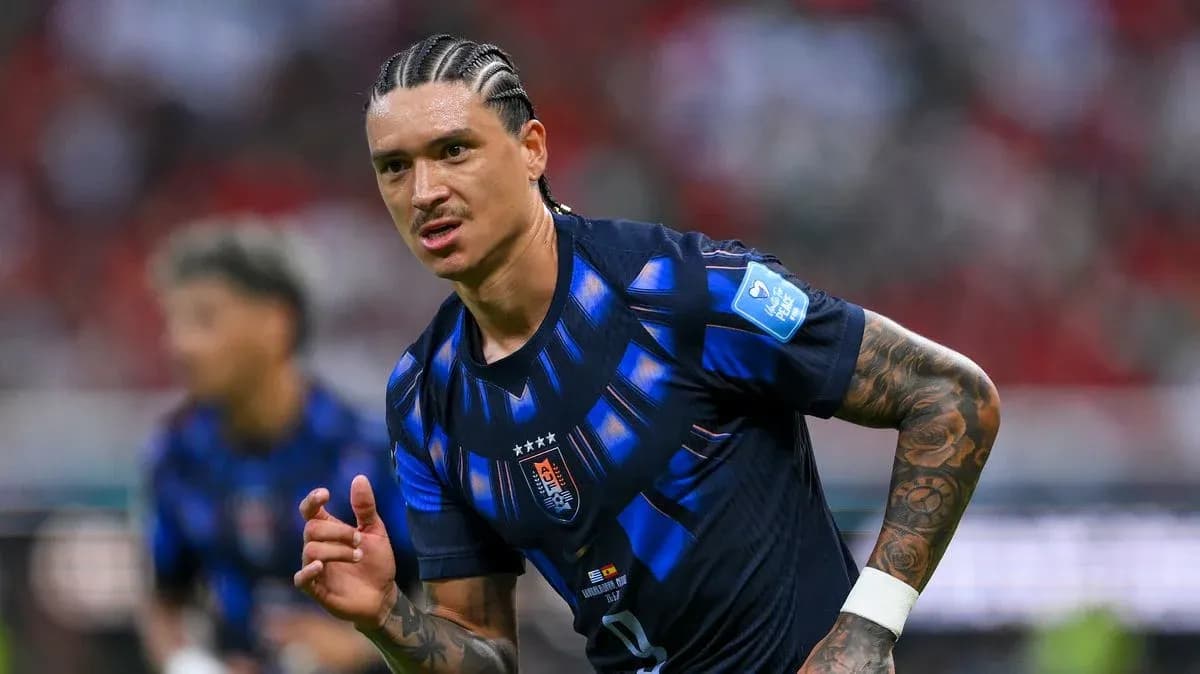 Futbolchi maydonda harakatda, boshqa o'yinchilar ortda Futbolchi maydonda harakatda, boshqa o'yinchilar ortda