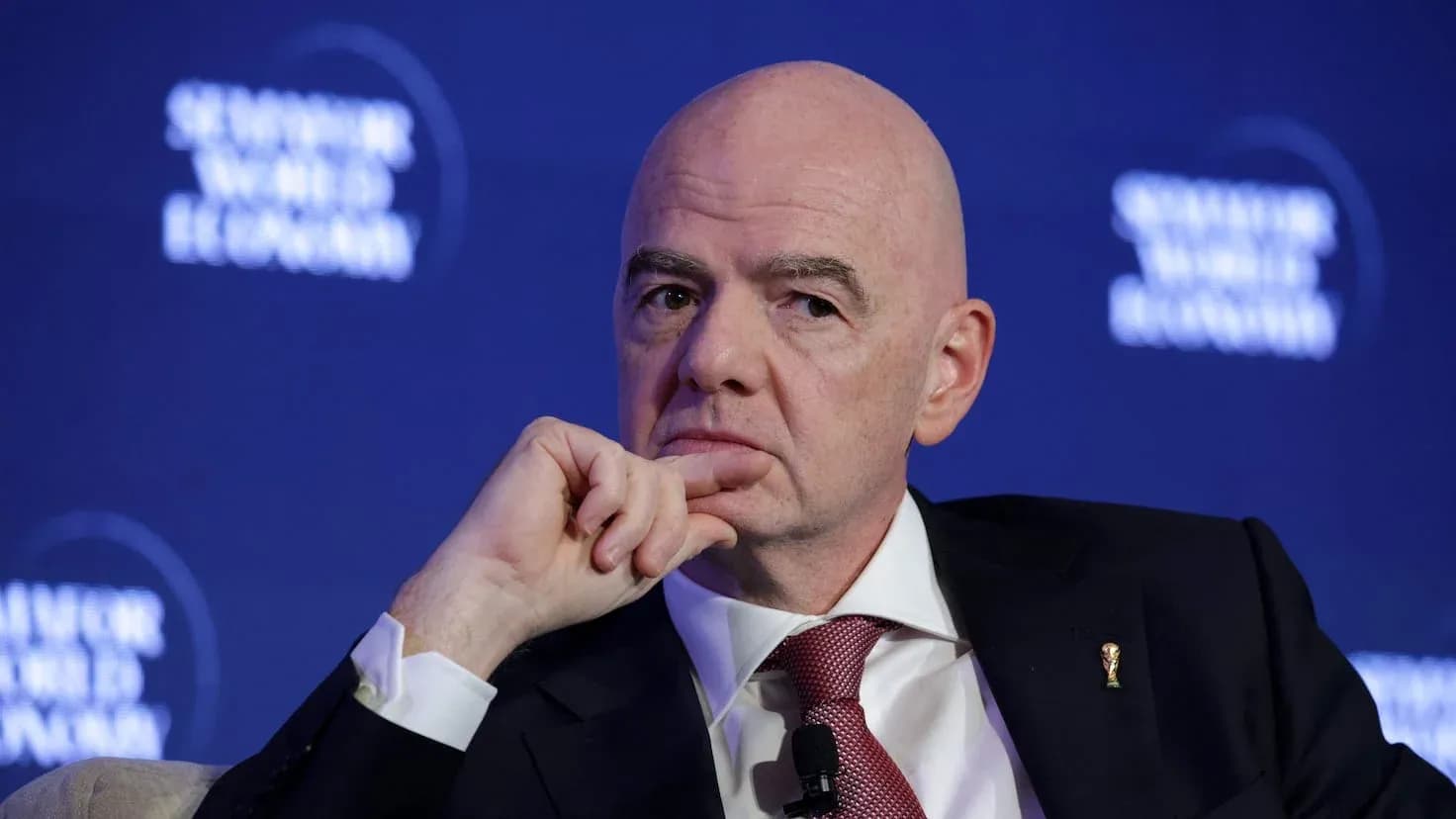 Man speaking at a conference with FIFA logo Man speaking at a conference with FIFA logo
