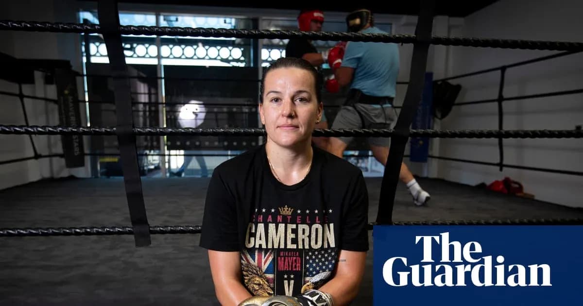 Boxer seated in ring with training session behind Boxer seated in ring with training session behind