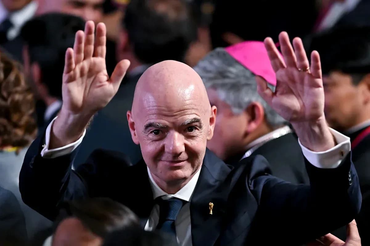 Person waving at an event with attendees in background Person waving at an event with attendees in background