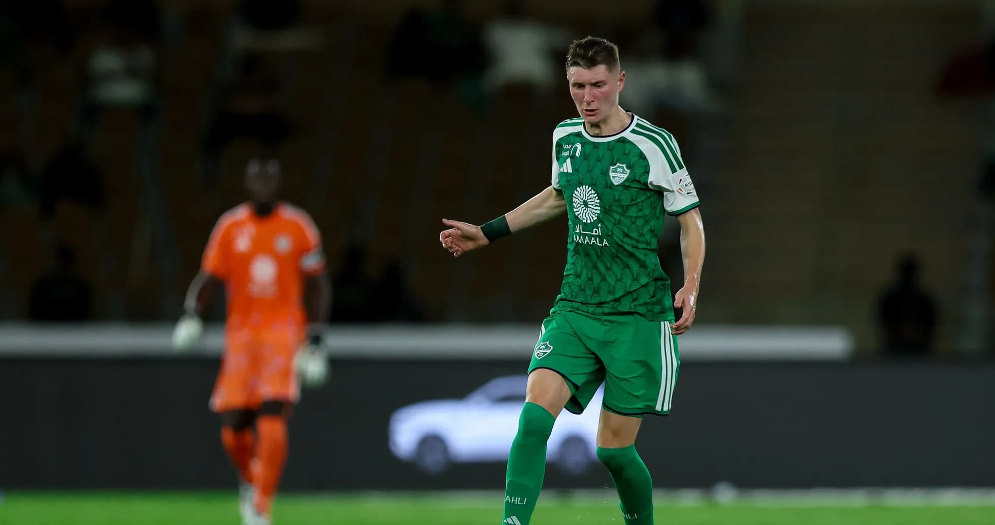 Futbolchi to'pni ushlab, raqibga qarab turibdi Futbolchi to'pni ushlab, raqibga qarab turibdi