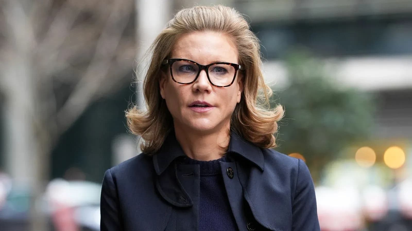 Woman in glasses walking outdoors with trees behind Woman in glasses walking outdoors with trees behind