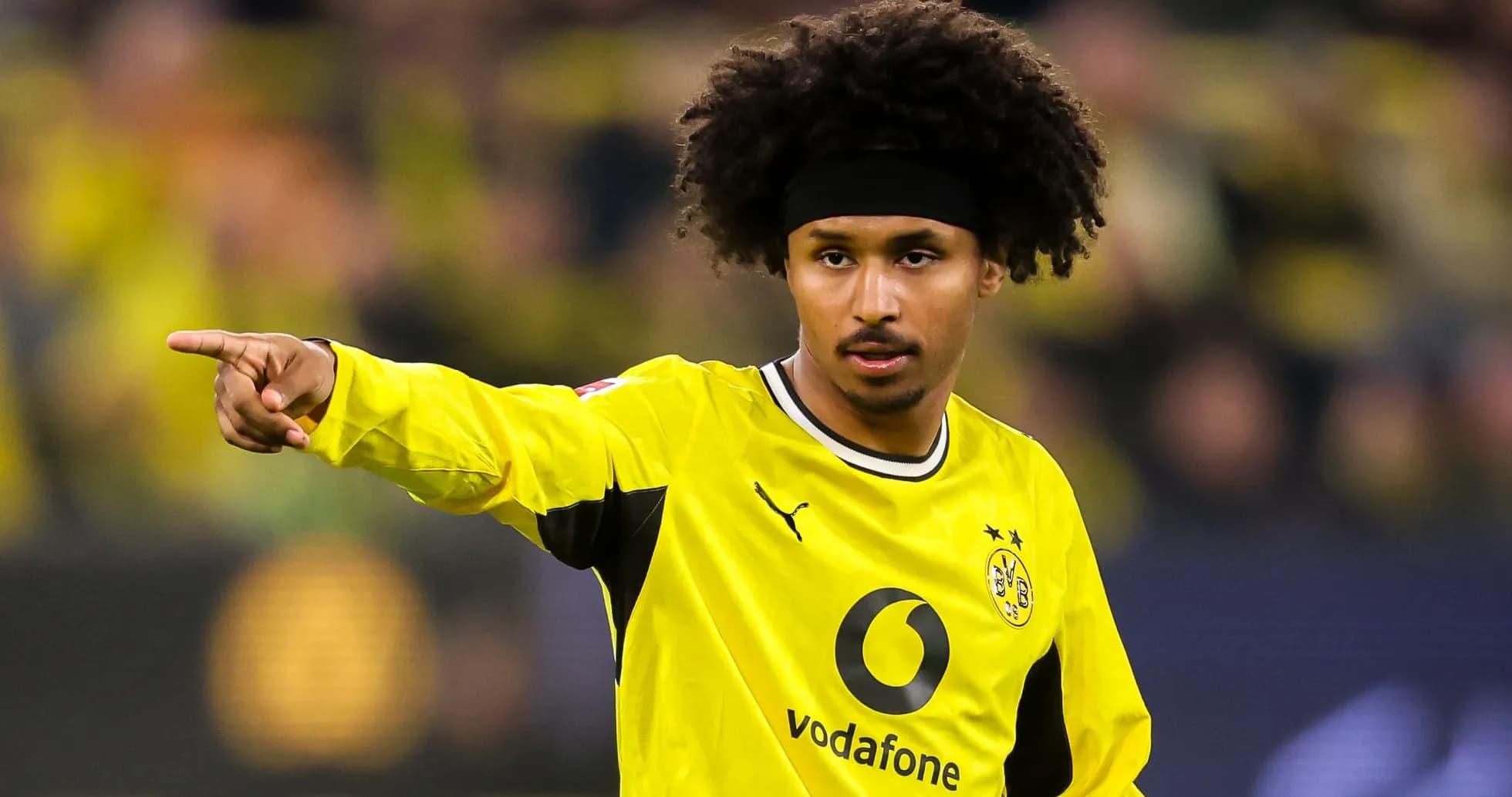 Futbolchi maydonni ko'rsatmoqda, jamoasi sariq formada Futbolchi maydonni ko'rsatmoqda, jamoasi sariq formada