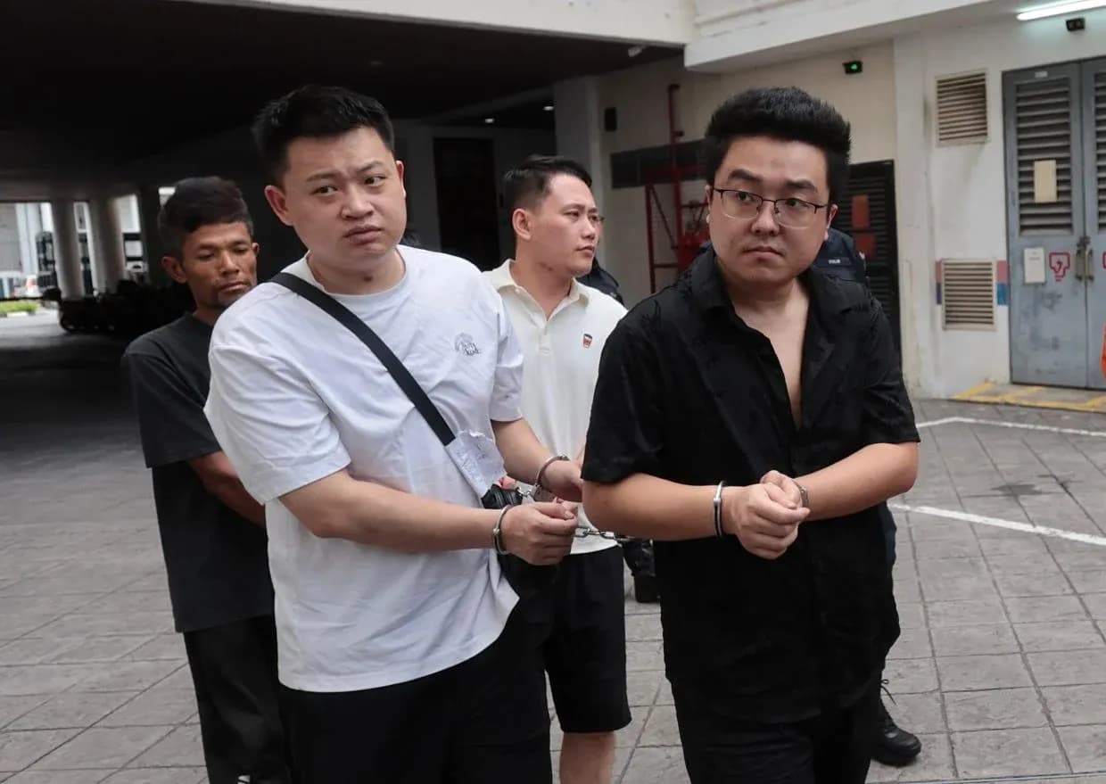 Four individuals in handcuffs walking outside building Four individuals in handcuffs walking outside building