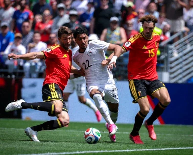 Two players tackling an Egyptian player during match Two players tackling an Egyptian player during match