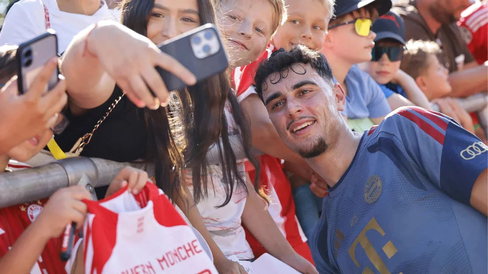 Futbolchi bolalar bilan suratga tushmoqda Futbolchi bolalar bilan suratga tushmoqda
