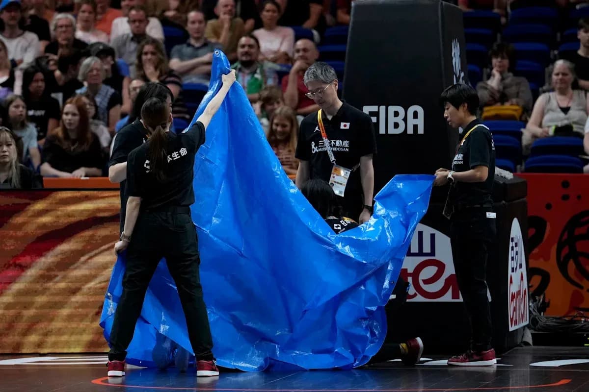 Staff covering court with blue tarp during event Staff covering court with blue tarp during event