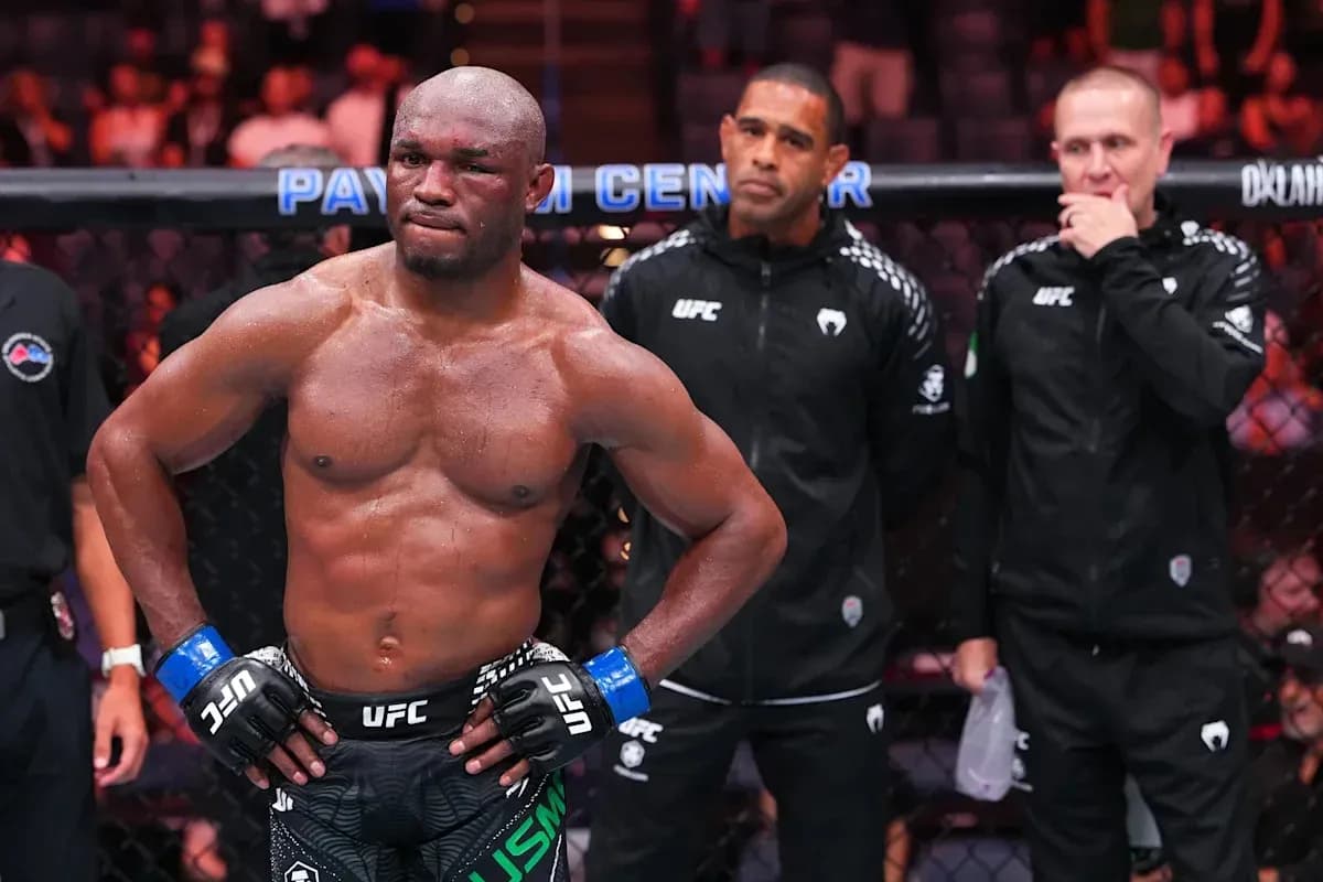Fighter in octagon with coaches observing behind Fighter in octagon with coaches observing behind