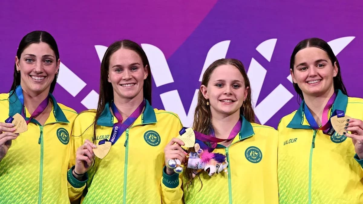 Four swimmers celebrating with gold medals on podium Four swimmers celebrating with gold medals on podium