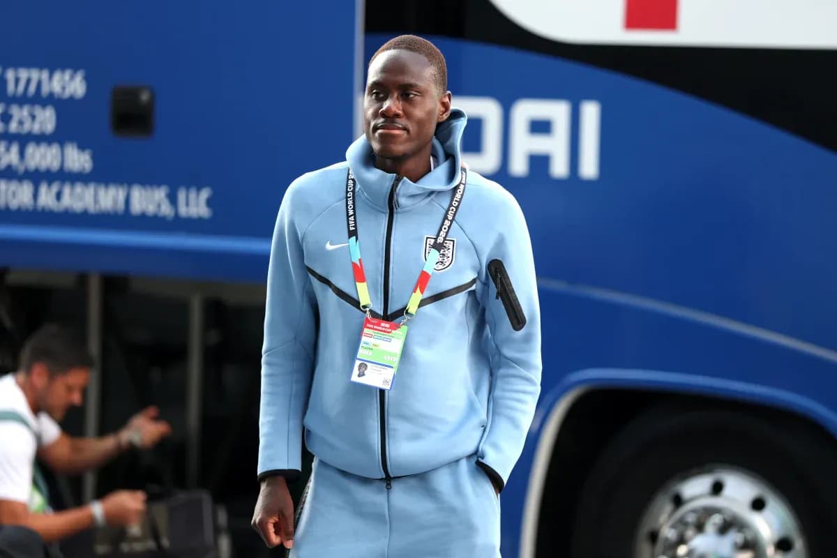 Futbolchi avtobus oldida ko'k kiyimda turibdi Futbolchi avtobus oldida ko'k kiyimda turibdi