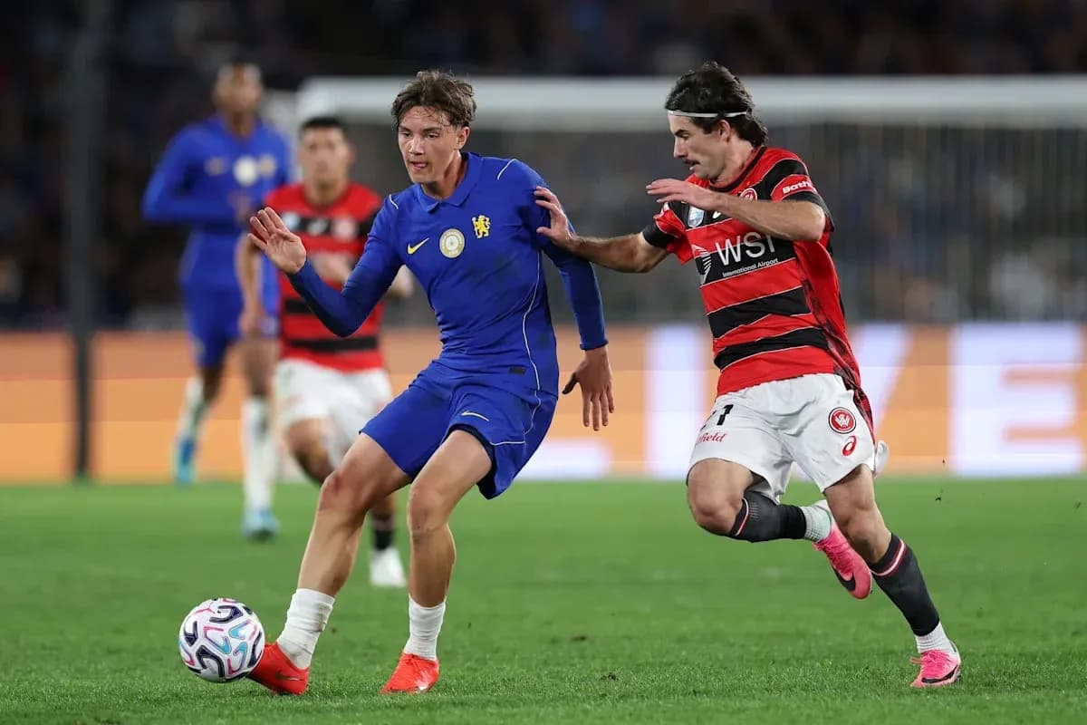 Player in blue jersey dribbling past opponent in red Player in blue jersey dribbling past opponent in red