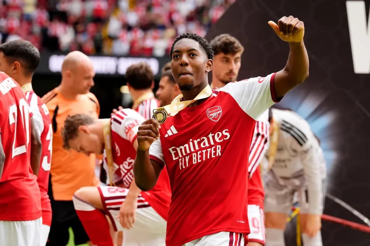 Arsenal player celebrating with a medal after match Arsenal player celebrating with a medal after match