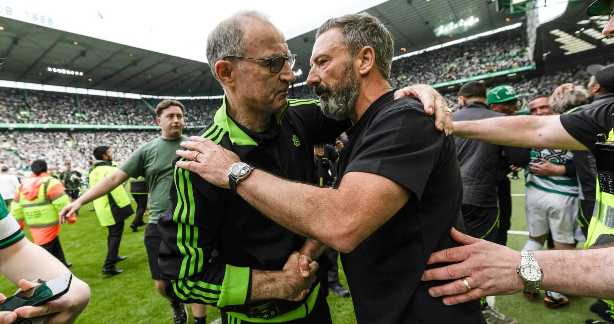 Two coaches embracing on the pitch after match Two coaches embracing on the pitch after match