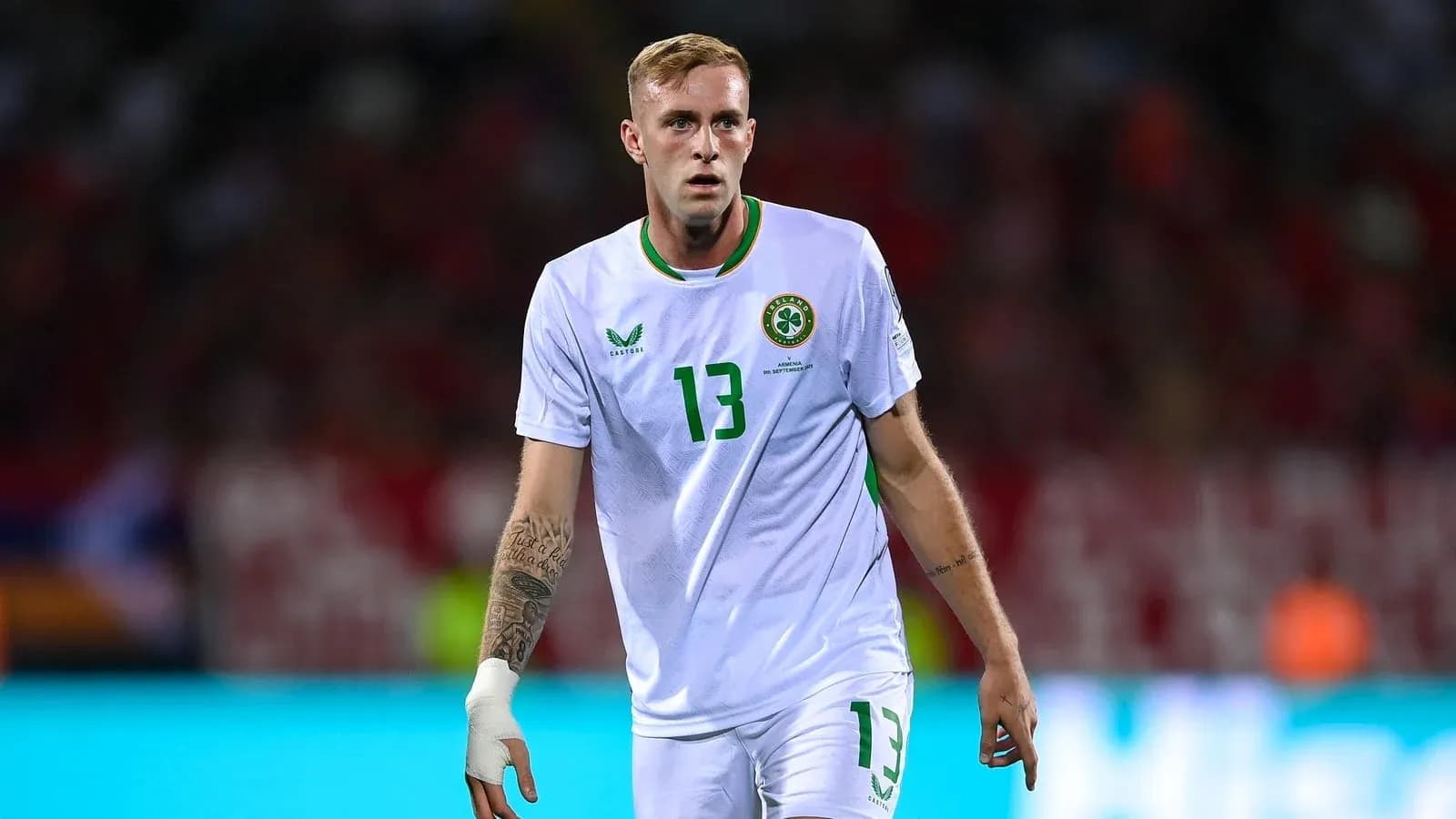 Futbolchi maydonda harakatda, oq forma kiygan Futbolchi maydonda harakatda, oq forma kiygan