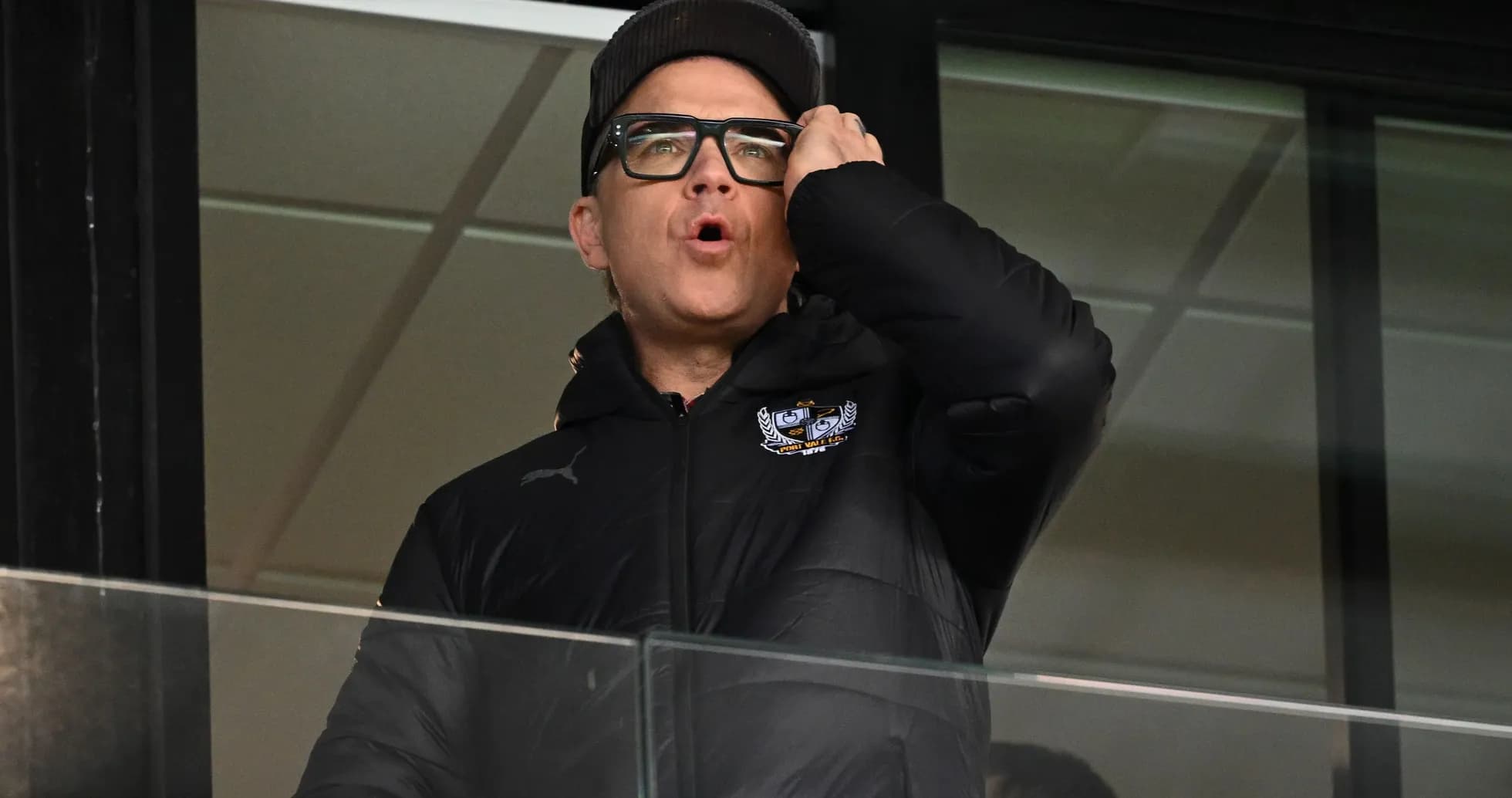 Man in black jacket speaking from a balcony Man in black jacket speaking from a balcony