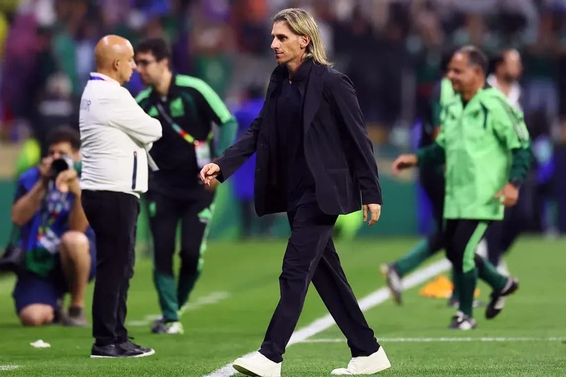 Coach walking on the pitch during a match Coach walking on the pitch during a match