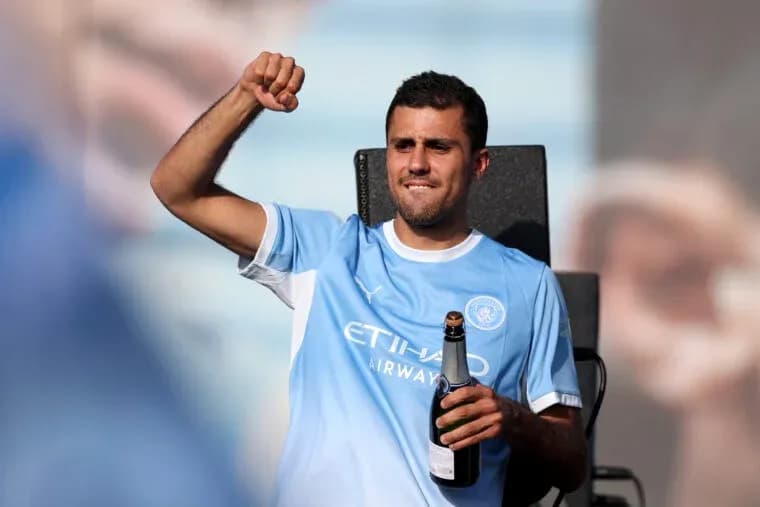 Futbolchi shampan bilan maydonda qo'lni ko'targan Futbolchi shampan bilan maydonda qo'lni ko'targan