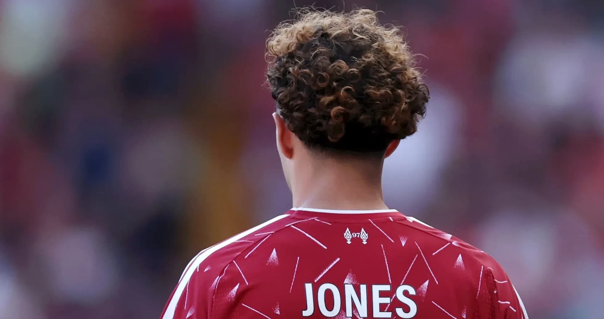 Futbolchi orqa tomondan, JONES nomi ko'rinadi Futbolchi orqa tomondan, JONES nomi ko'rinadi