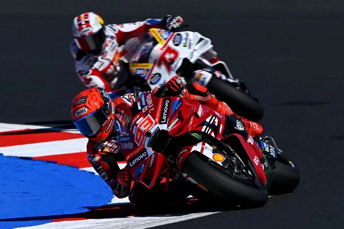 Ducati rider cornering with another racer behind Ducati rider cornering with another racer behind
