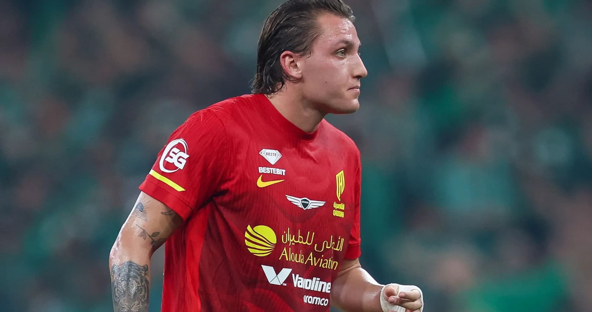 Futbolchi qizil forma kiyib, maydonda harakatda Futbolchi qizil forma kiyib, maydonda harakatda