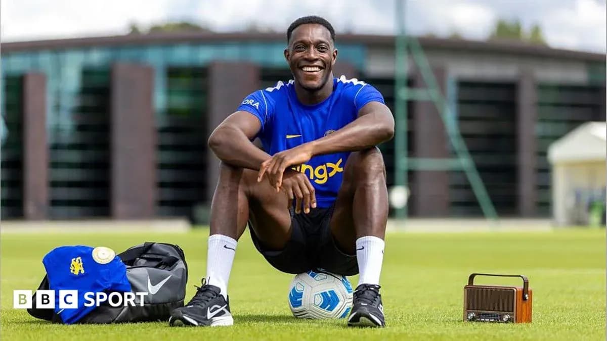 Futbolchi o'yin maydonida kulib o'tirgan Futbolchi o'yin maydonida kulib o'tirgan