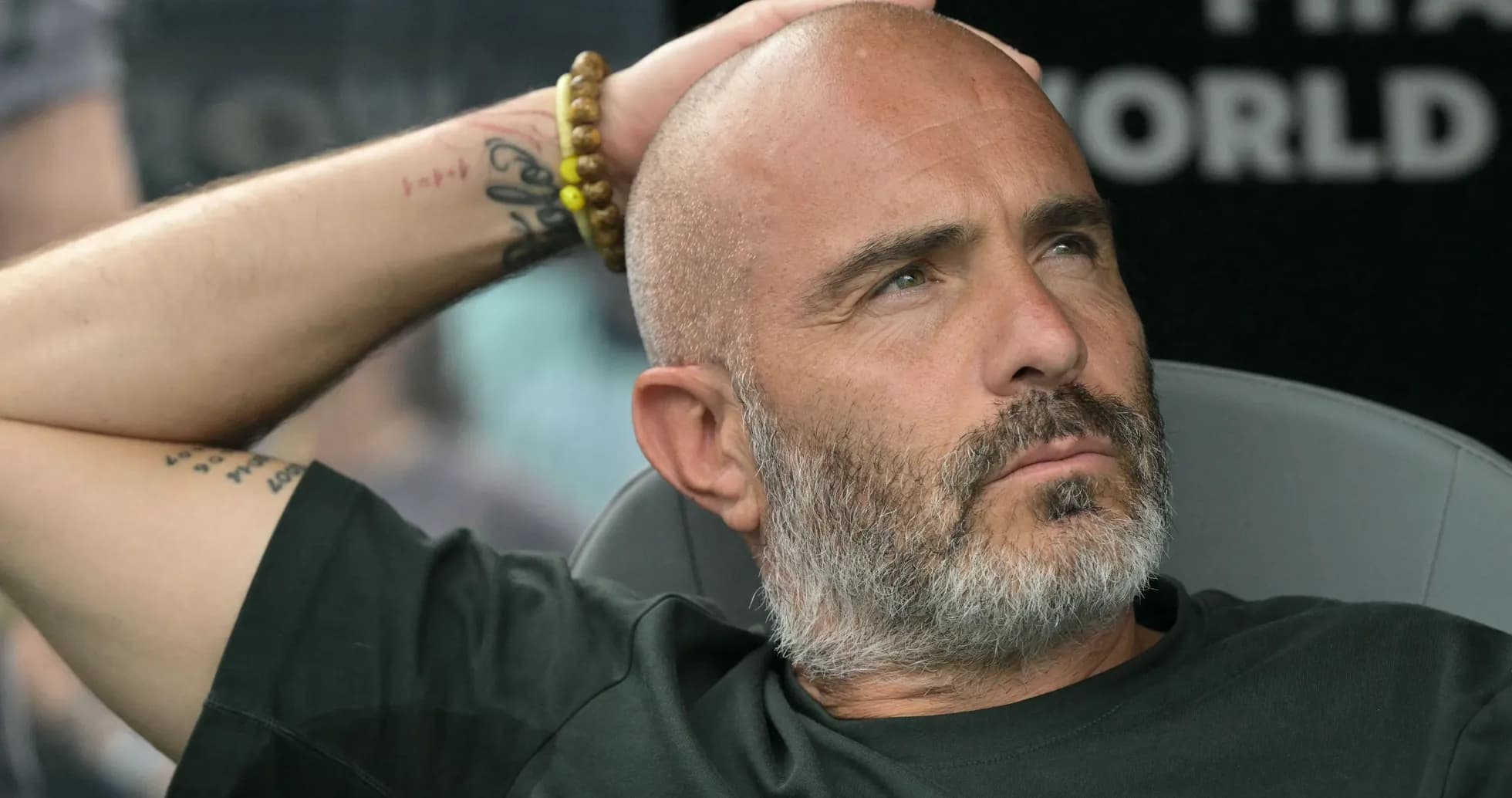 Bald man with beard resting during match Bald man with beard resting during match