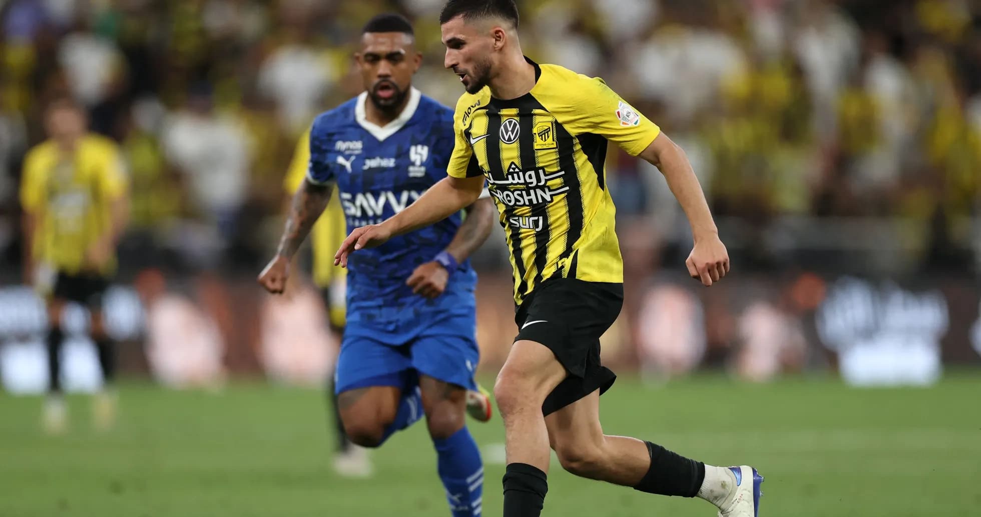 Ittihad player dribbling past Al Hilal opponent Ittihad player dribbling past Al Hilal opponent