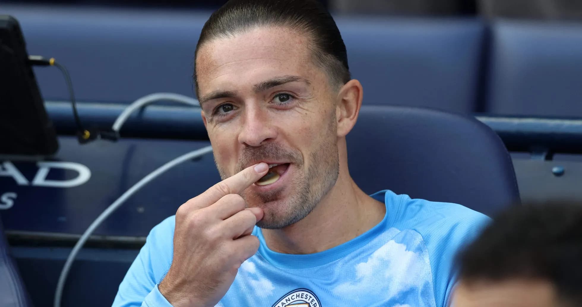 Futbolchi benchtan ovqat iste'mol qilmoqda Futbolchi benchtan ovqat iste'mol qilmoqda