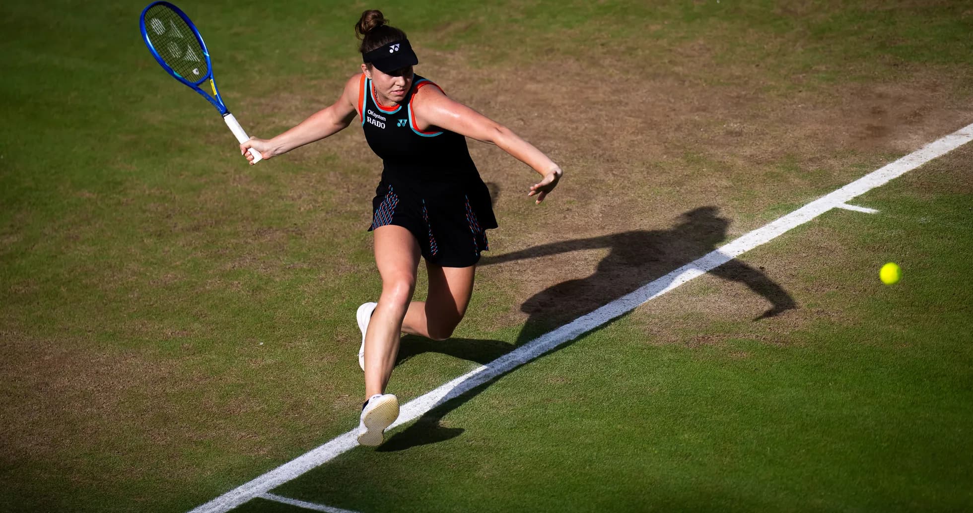 Tennis player hitting a forehand on grass court Tennis player hitting a forehand on grass court