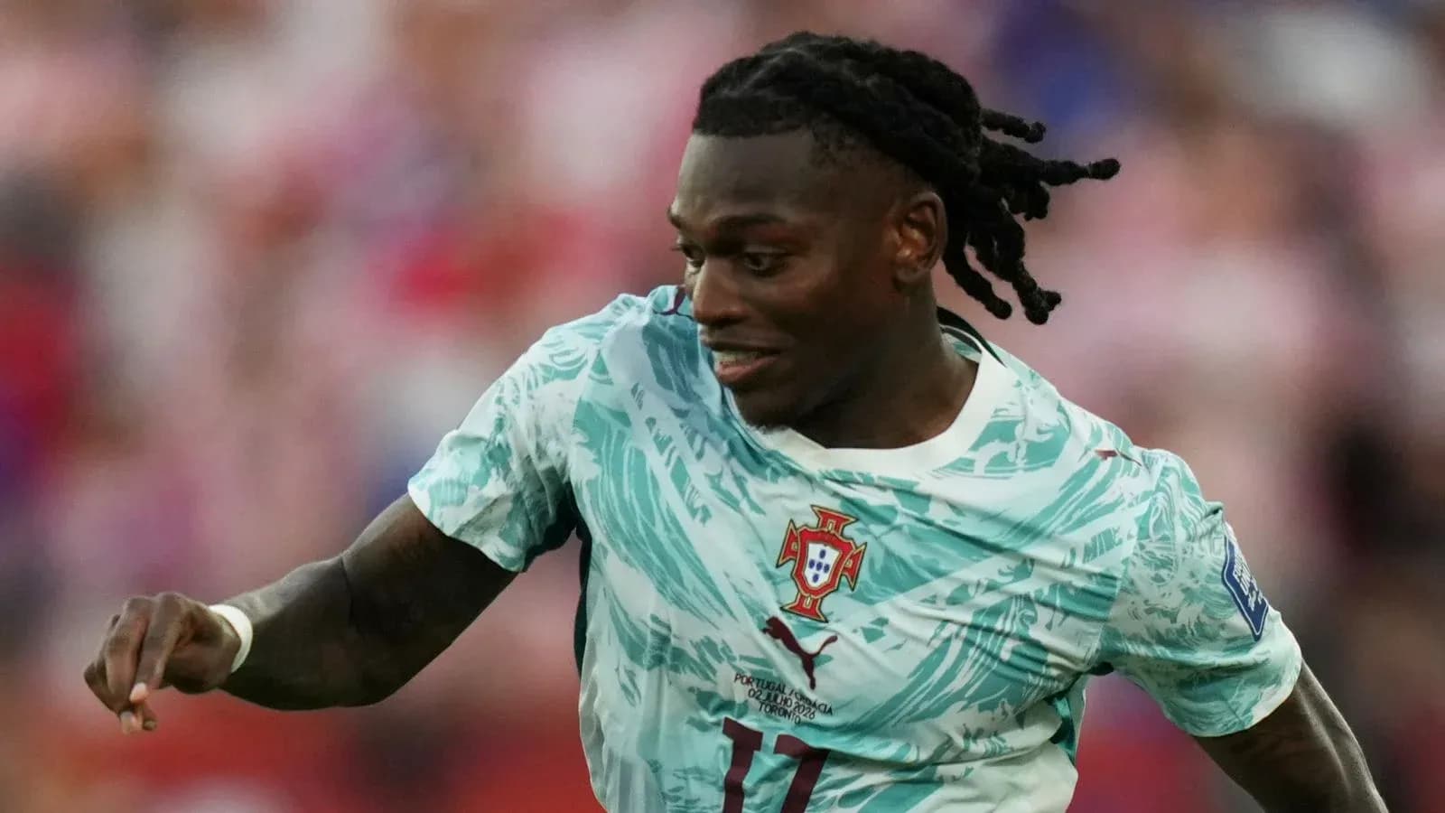 Futbolchi Portugal formasida to'pni ushlamoqda Futbolchi Portugal formasida to'pni ushlamoqda
