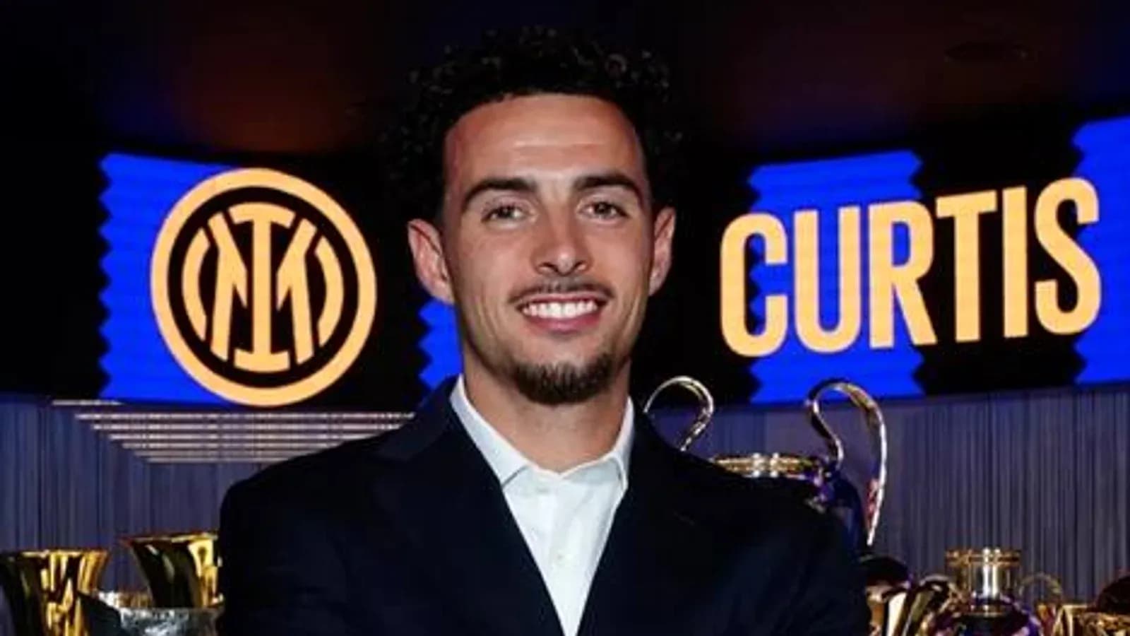 Futbolchi mukofotlar oldida tabassum qilmoqda Futbolchi mukofotlar oldida tabassum qilmoqda