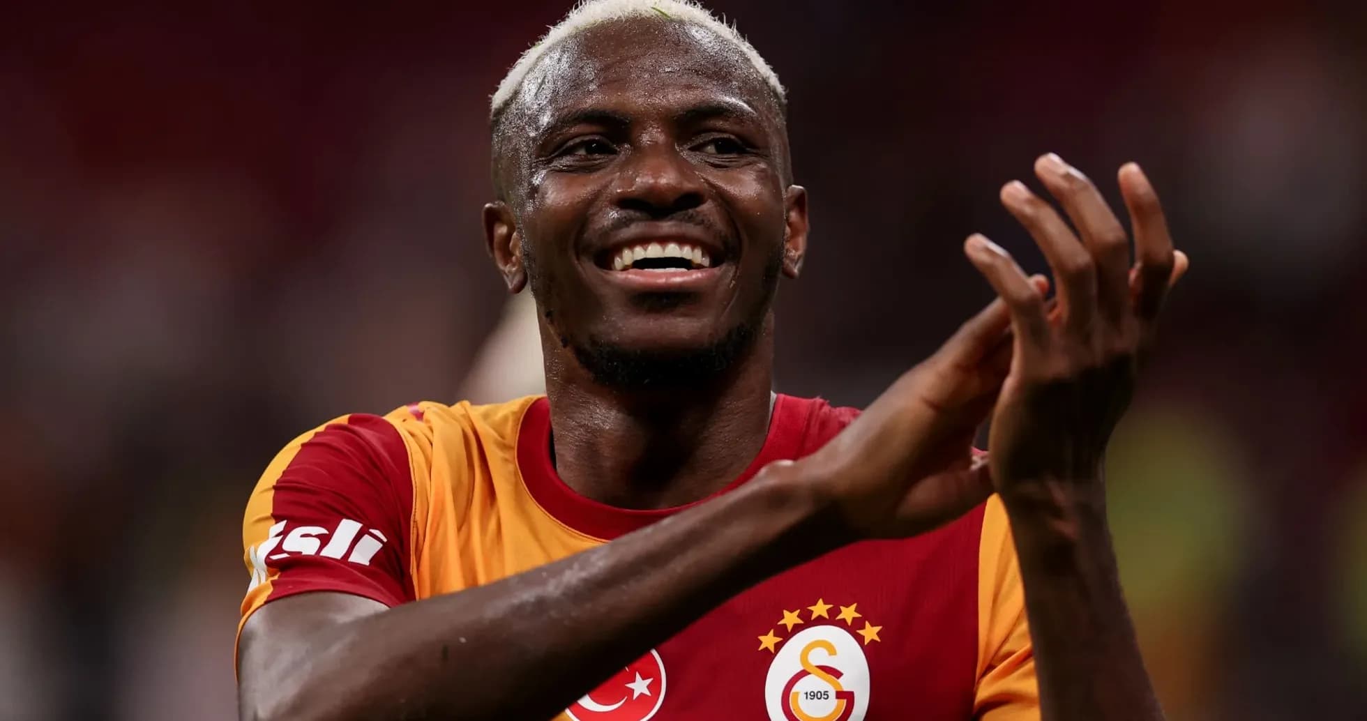 Futbolchi olovda qo'llarini tepaga ko'tarib turgan Futbolchi olovda qo'llarini tepaga ko'tarib turgan